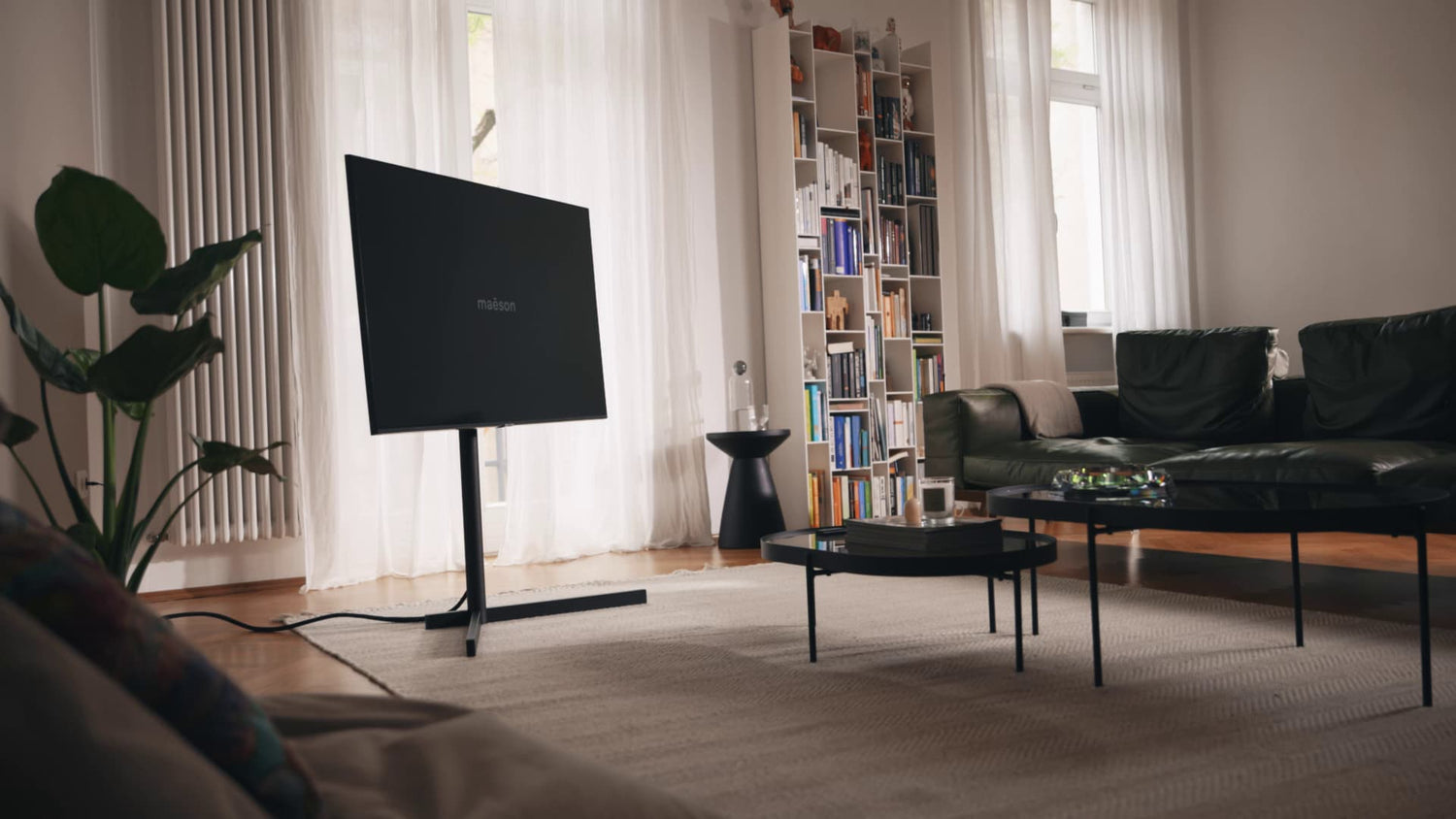 AURA freistehender Fernsehständer in Mattschwarz im Wohnzimmer